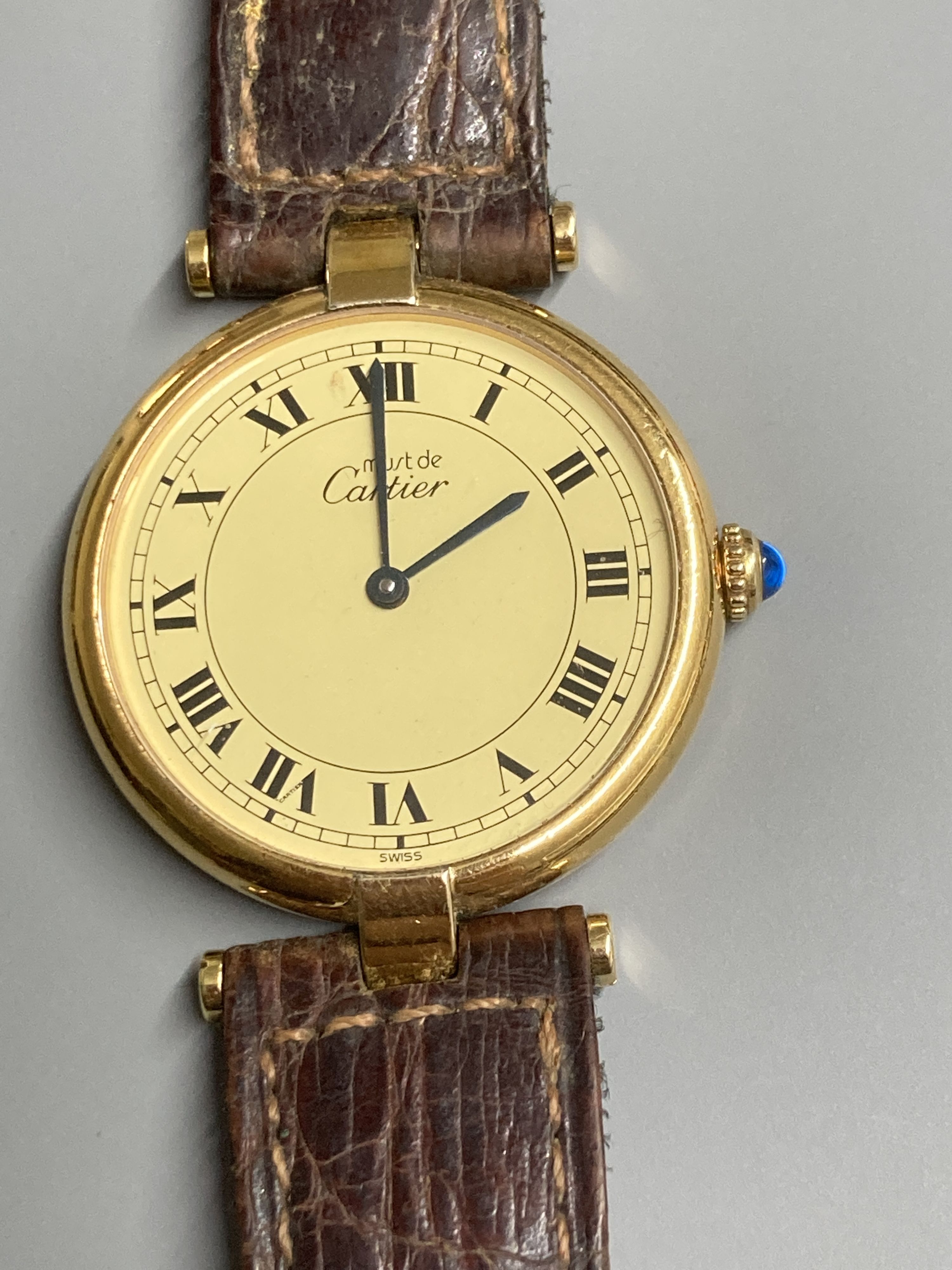 A modern Cartier Vermeil gilt 925 quartz wrist watch, with circular Roman dial and cabochon set crown, on a Cartier leather strap, case diameter 30mm ex. crown.